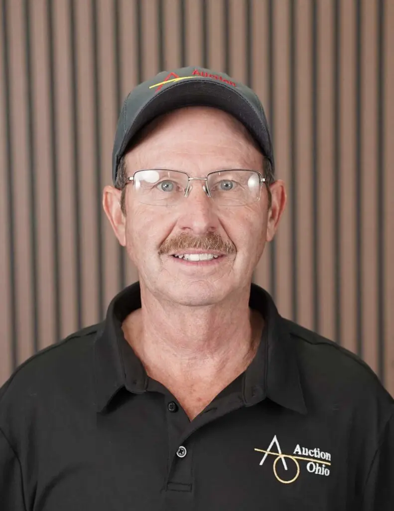 Man in baseball cap and shirt, smiling.
