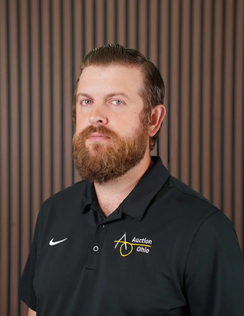 Bearded man in Auction Ohio polo shirt.