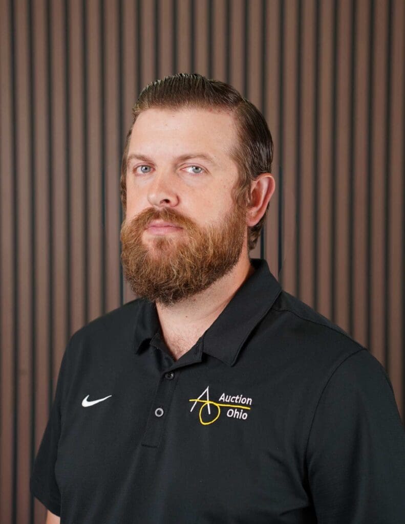 Bearded man in Auction Ohio polo shirt.