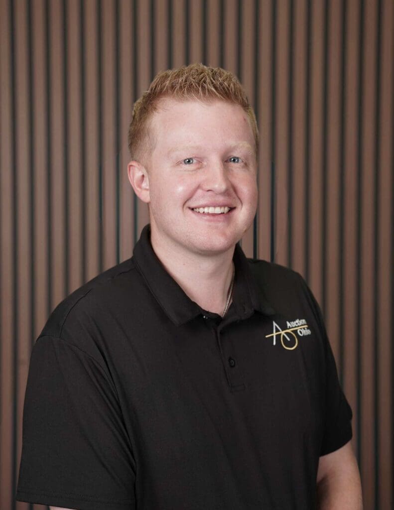 Smiling person in black shirt with logo