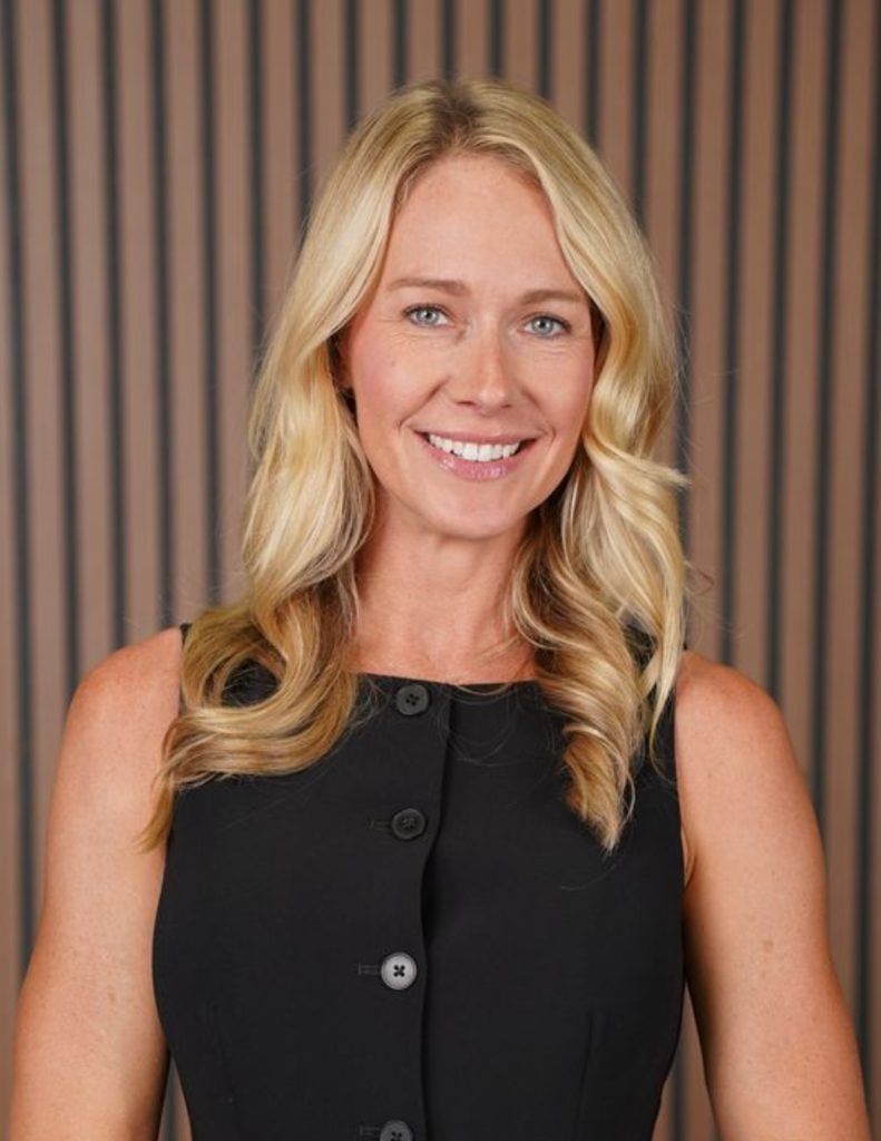 Smiling woman with long blonde hair, black dress.