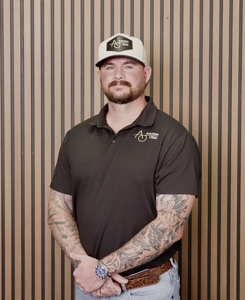Man in branded polo and cap, wood backdrop