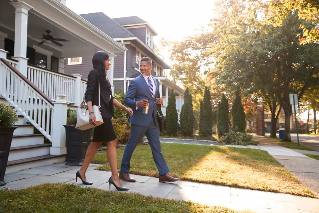 Business professionals walking in suburban neighborhood at sunrise