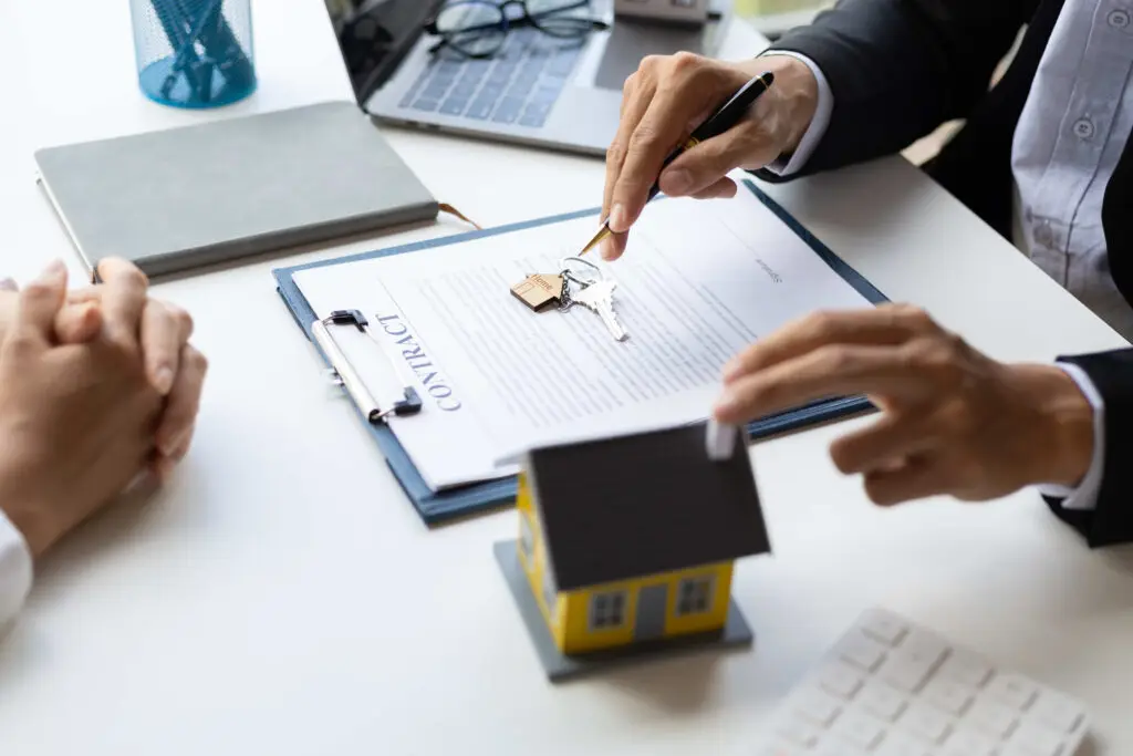 Real estate agent presenting keys over contract